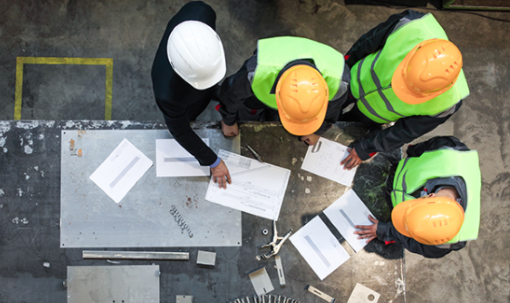 Men in a circle discussing construction plans