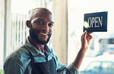 Image of person holding an open sign.