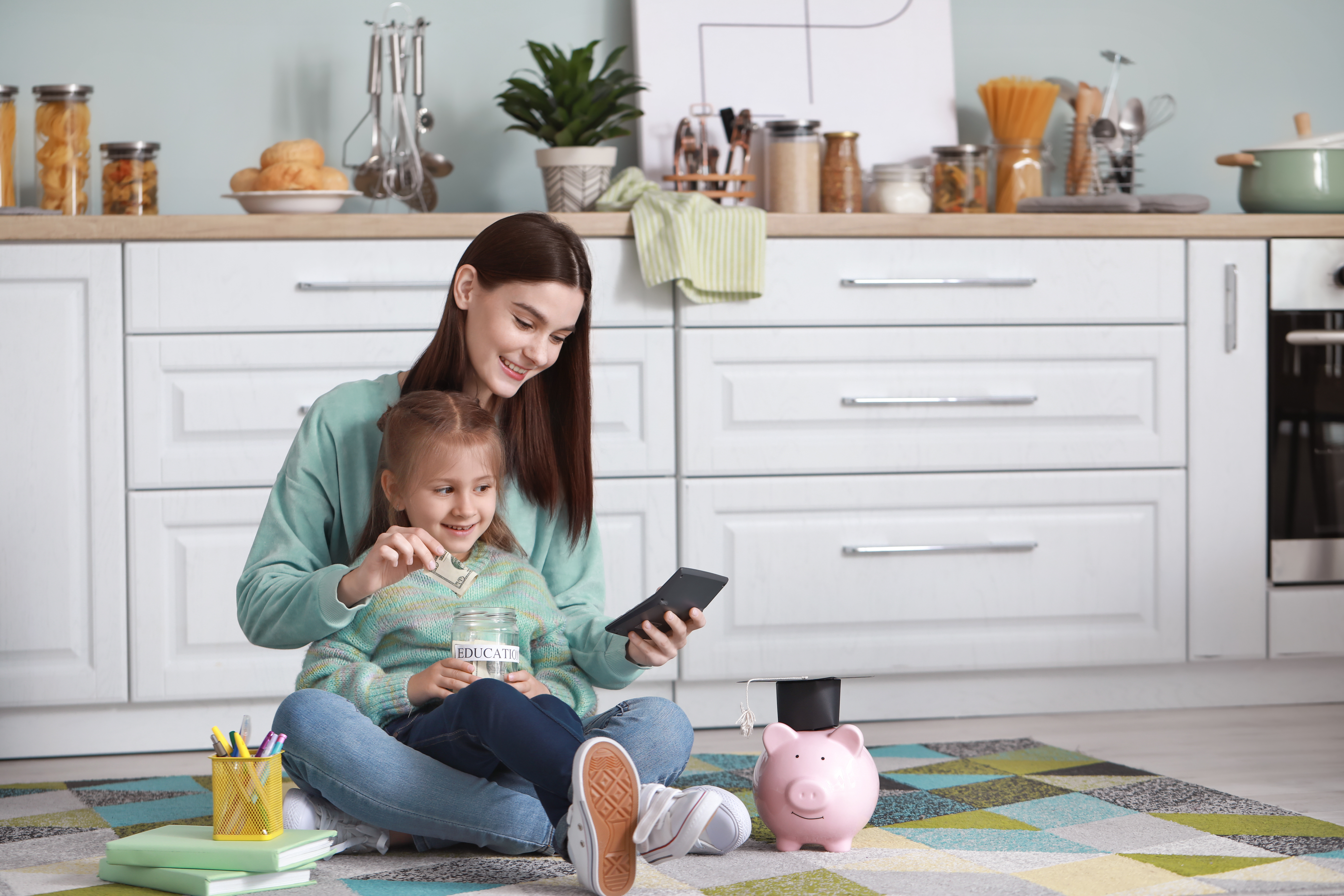 Little girl and her mother with savings for education at home