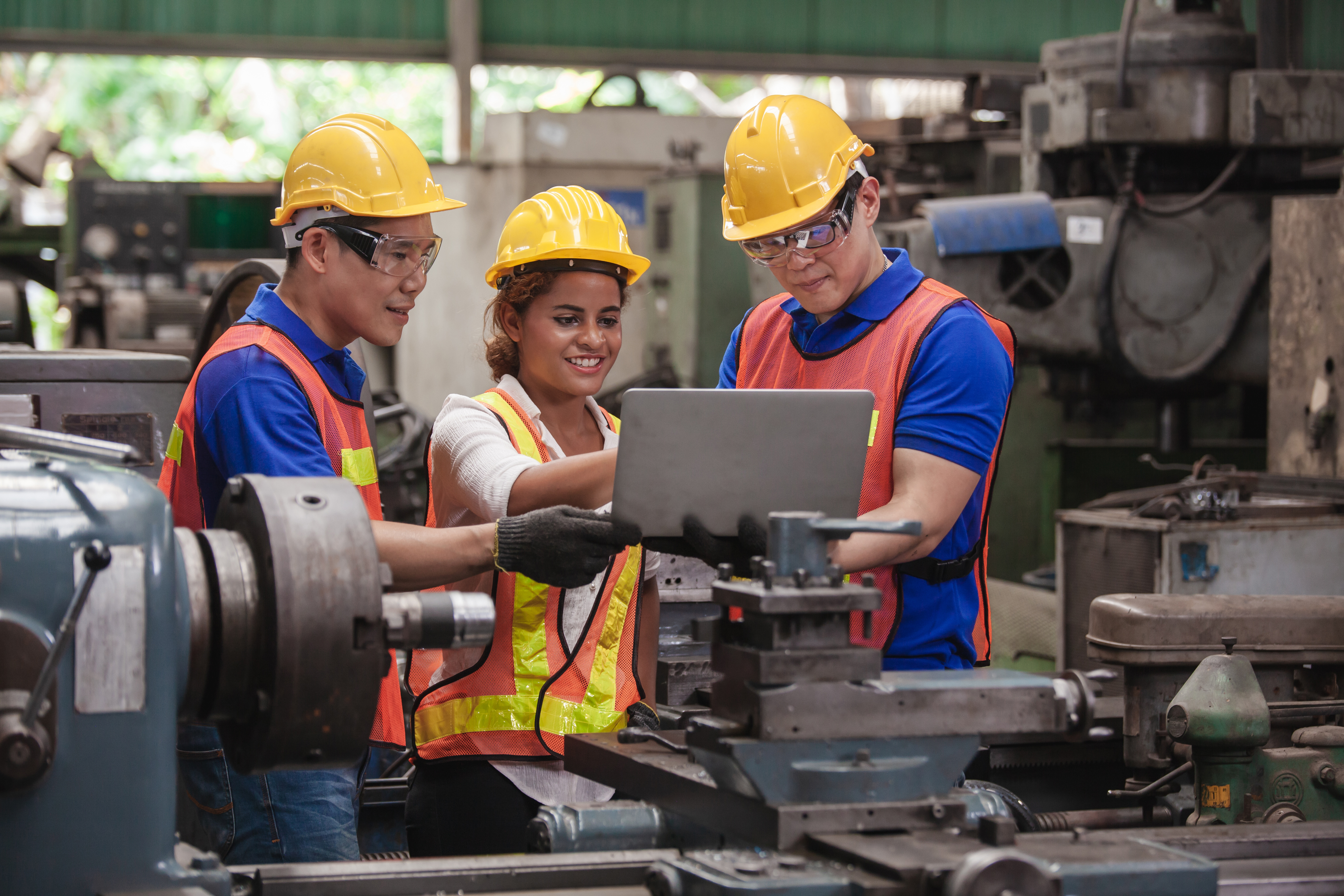 Industrial workers looking at laptop screen.