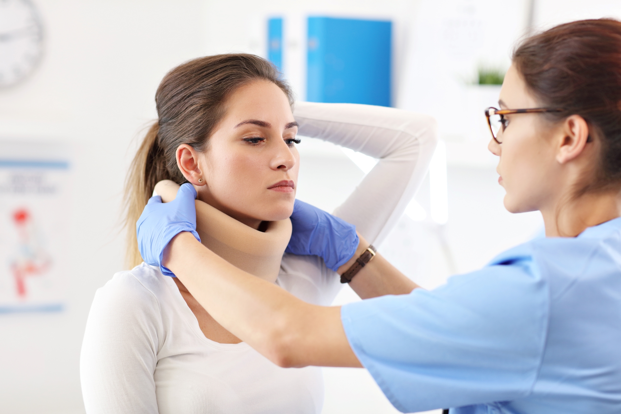 Female doctor putting neck orthopedic collar on adult injured woman