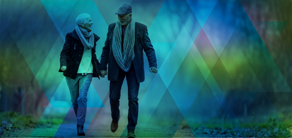 Retired couple walking and holding hands in cold weather.