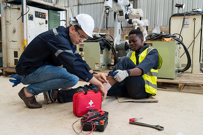 Worker assists an colleague with an injury that could result in a Workers' Compensation Insurance claim, affecting their company's experience modification factor.